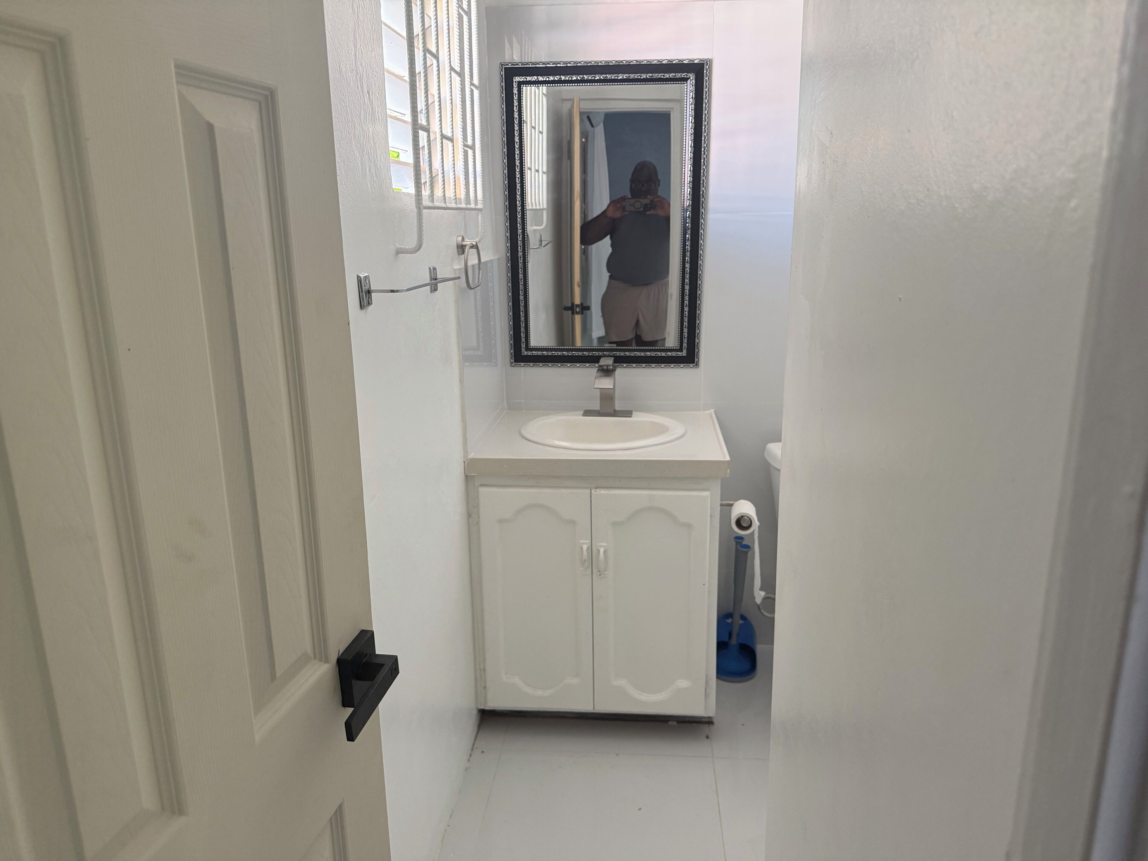 Ein Badezimmer mit weißem Waschbecken, Spiegel und Schrank.