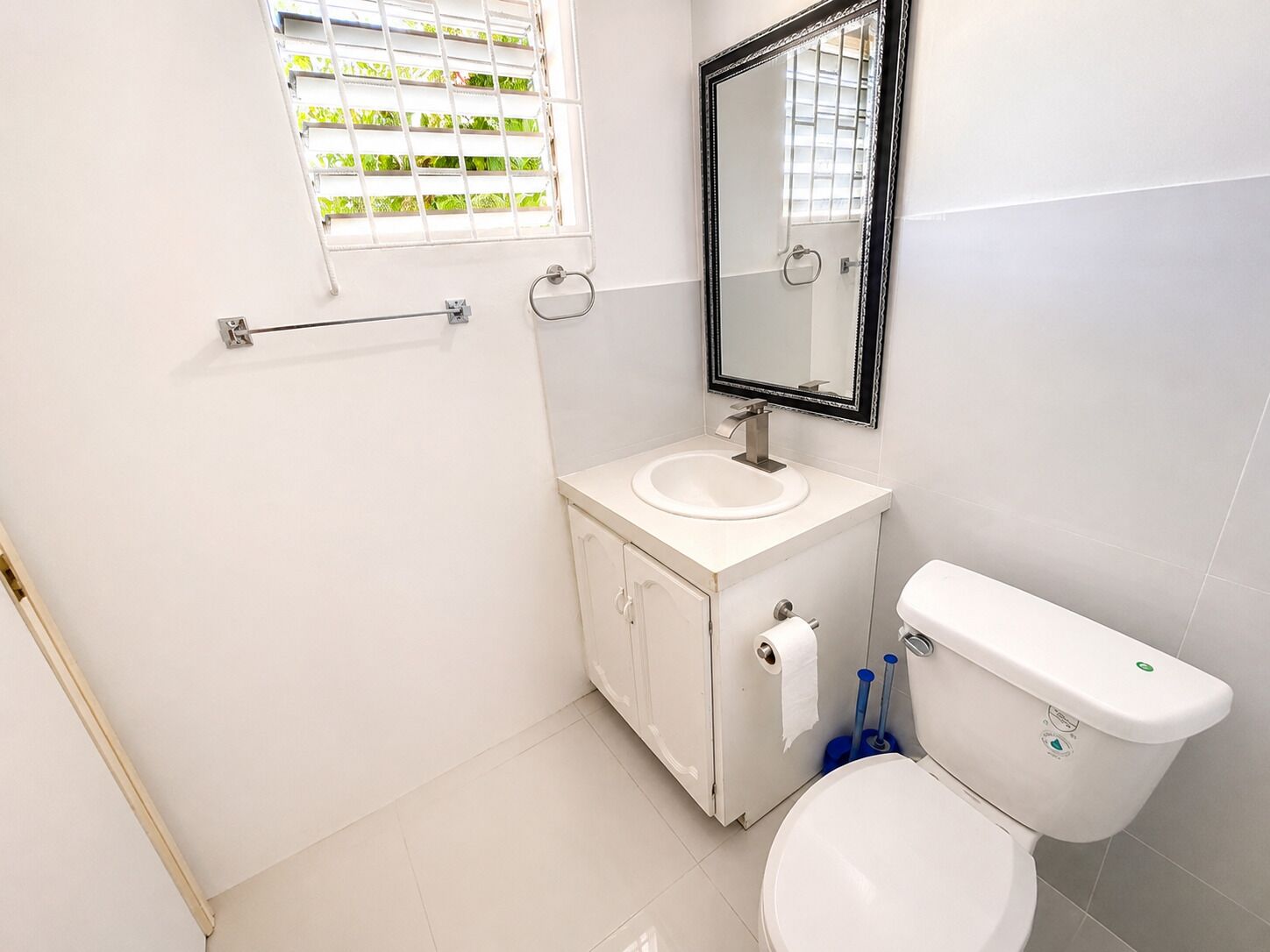 Ein Badezimmer mit Toilette, Waschbecken und Spiegel.