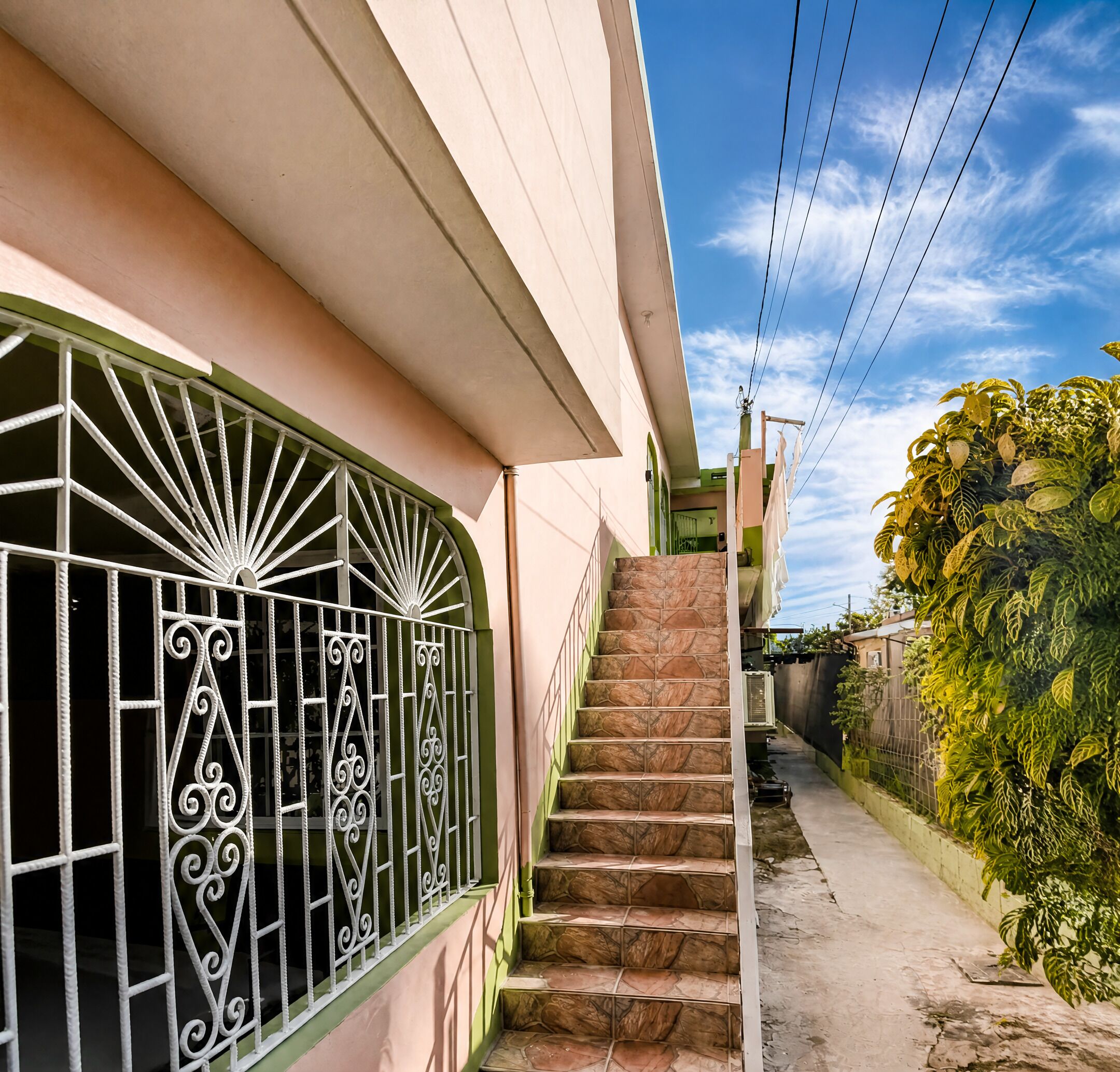 A staircase leading to a house with a decorative metal gate.