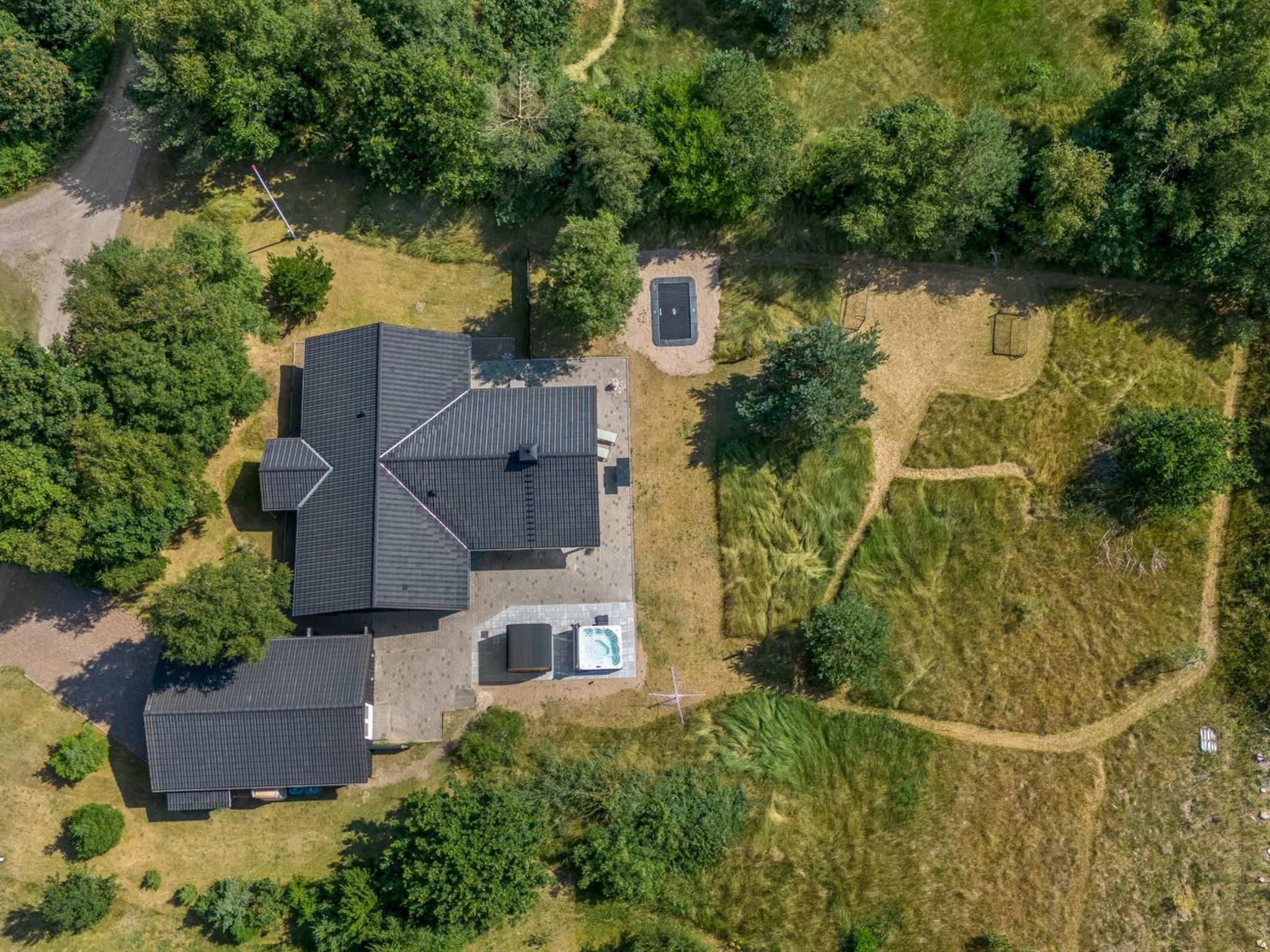 Een woonhuis met een groot huis, een zwembad en een verzorgde tuin.
