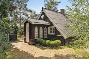 A wooden cabin with a sloped roof, large windows, and a chimney. - Fine old details near Stubbe Lake (Ebeltoft)