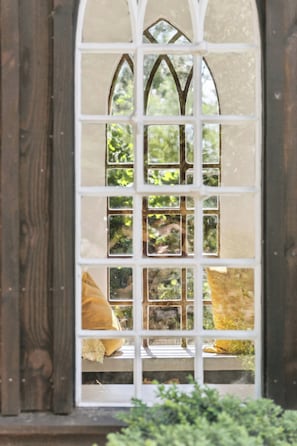 A window with a grid pattern and a view of greenery outside. - Fine old details near Stubbe Lake (Ebeltoft)