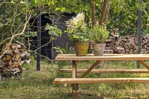 Una mesa de picnic de madera con dos plantas en macetas.