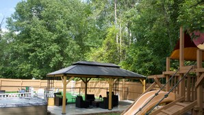 Ein Spielplatz mit Rutsche, Whirlpool und überdachter Sitzgelegenheit.