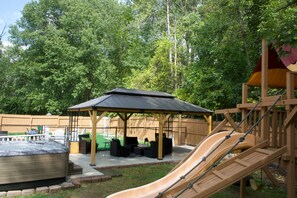 Ein Spielplatz mit Rutsche, Whirlpool und überdachter Sitzgelegenheit.