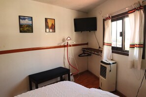A room with a bed, a bench, a wall-mounted TV, and a window with curtains. - Sky · Quiet pedestrian alley · Downtown Oaxaca (Oaxaca de Juárez)