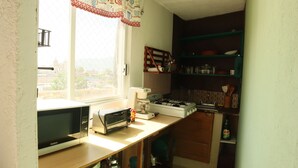 A compact kitchen with a microwave, toaster, and gas stove. - Sky · Quiet pedestrian alley · Downtown Oaxaca (Oaxaca de Juárez)