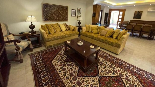 A living room with two sofas, a coffee table, and a patterned rug. - Cozy Villa with private pool (Al Shorouk City)