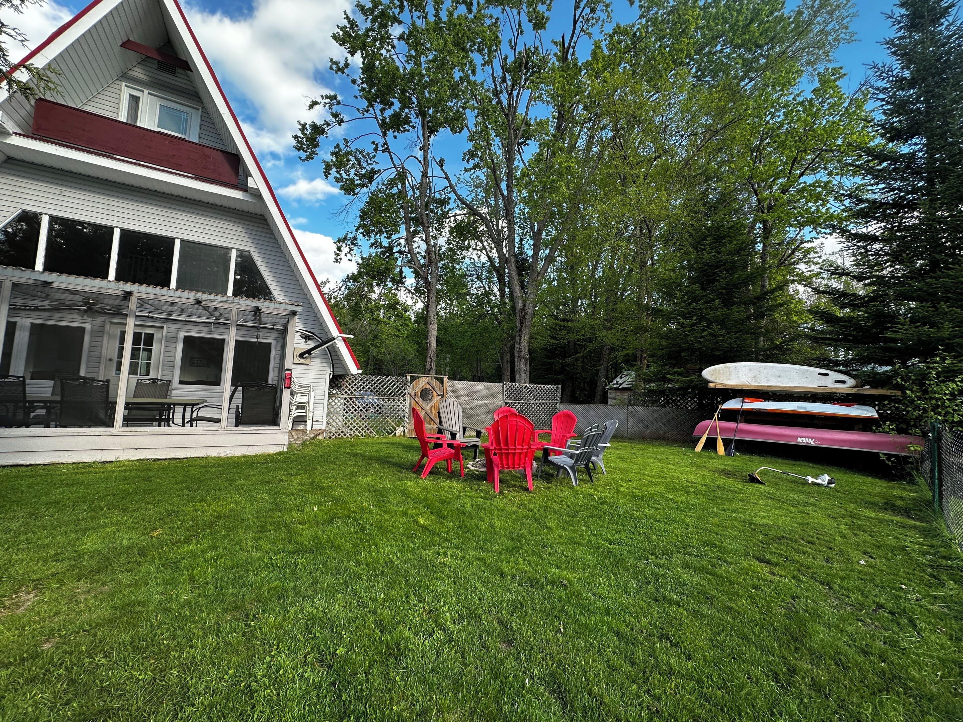 A house with a covered patio, a lawn, and outdoor seating.