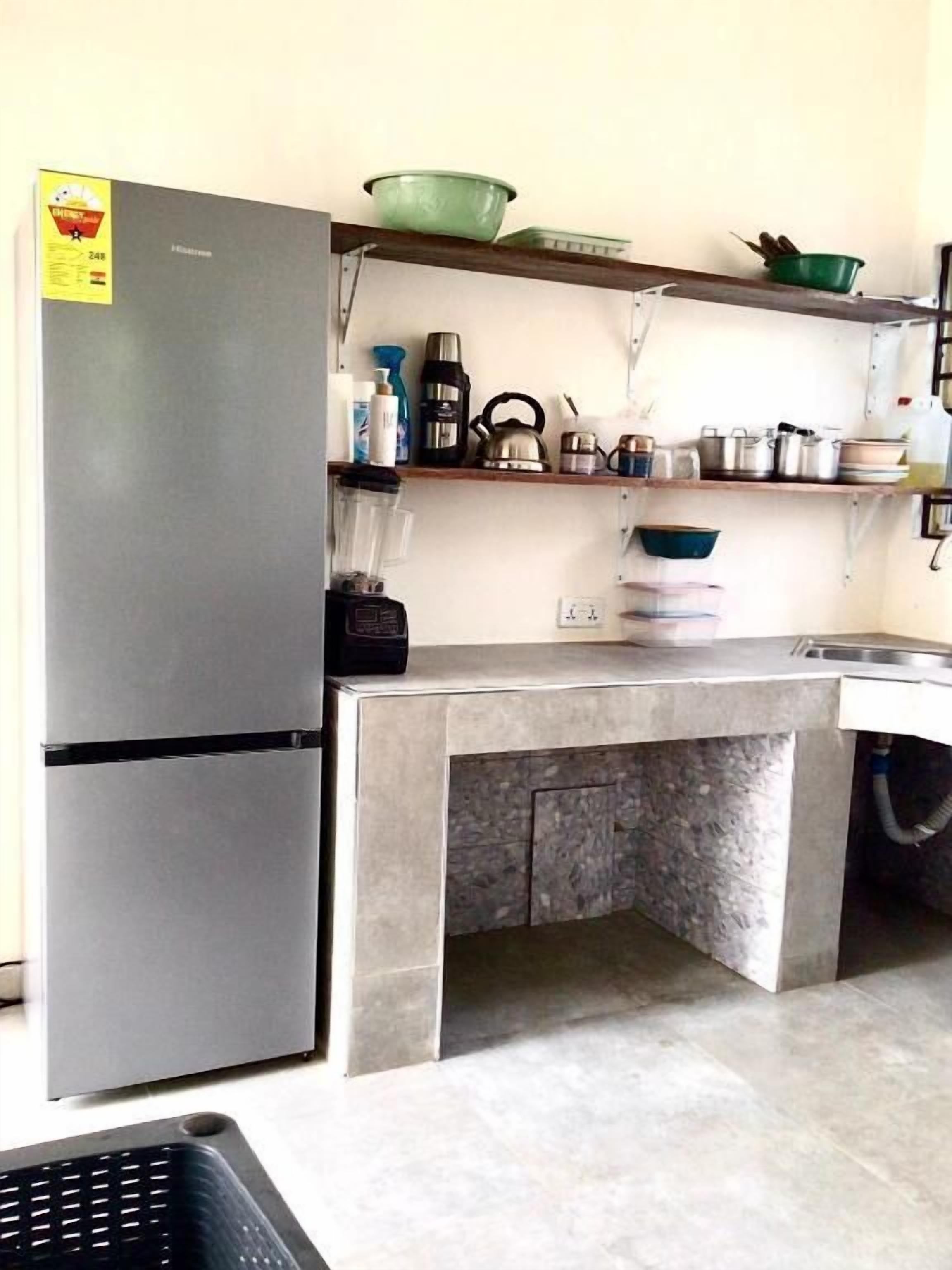 A compact kitchen with a built-in refrigerator, a countertop, and a sink.