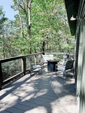 Um deck de madeira com mobiliário de exterior e churrasqueira.