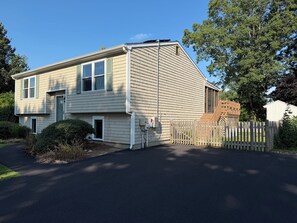 A two-story house with a front porch, a garage, and a fenced yard.