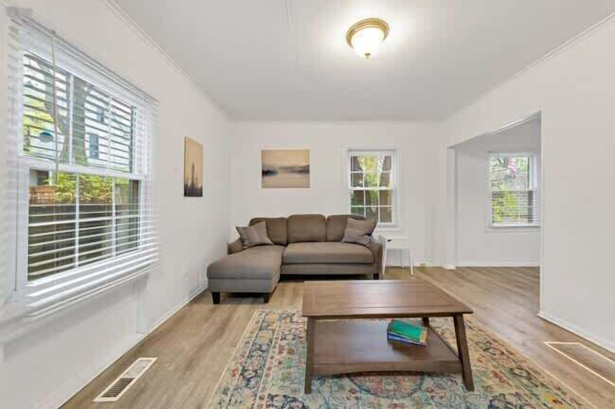 A living room with a sectional sofa, a coffee table, and a patterned rug.