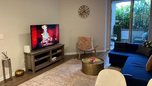 A living room with a television, a sofa, a coffee table, and a decorative chair. - Spacious 1bdrm apartment 10 mins to Cedars-Sinai by car FREE Parking, King bed (Los Angeles)