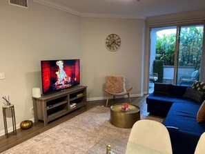 A living room with a television, a sofa, a coffee table, and a decorative chair. - Spacious 1bdrm apartment 10 mins to Cedars-Sinai by car FREE Parking, King bed (Los Angeles)