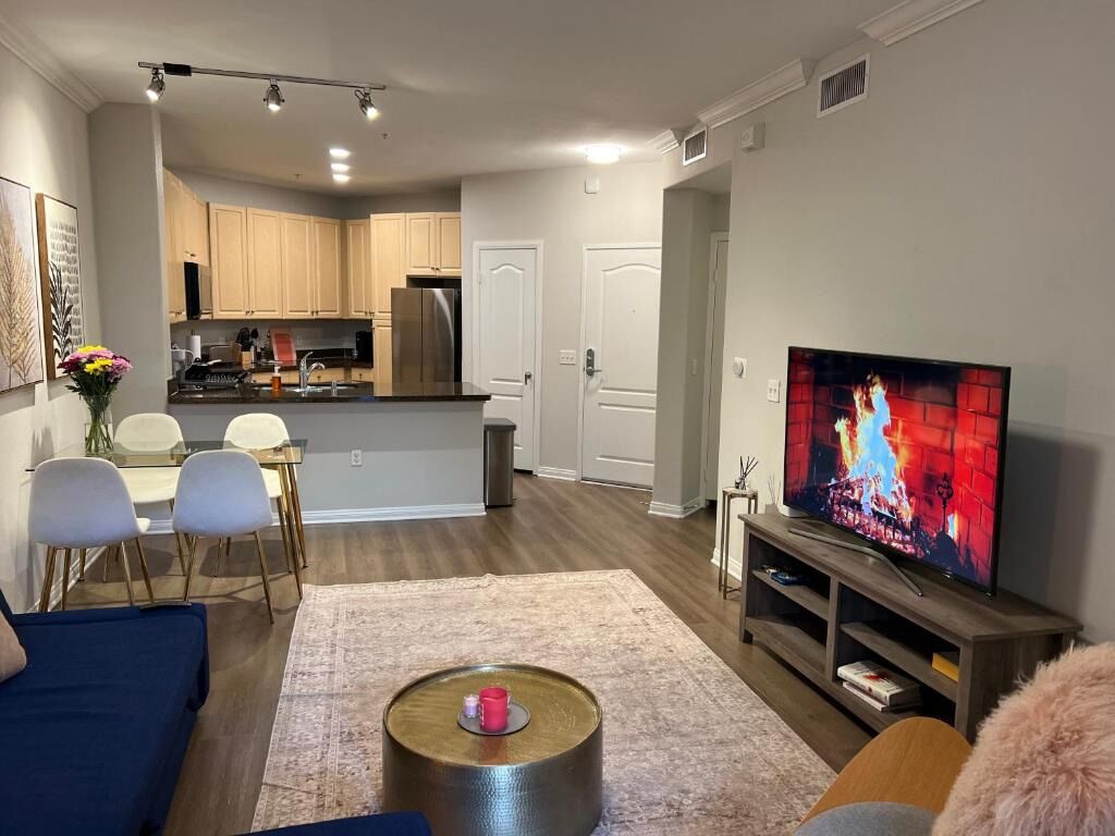 A modern living room with a flat-screen TV, a coffee table, and a sofa.