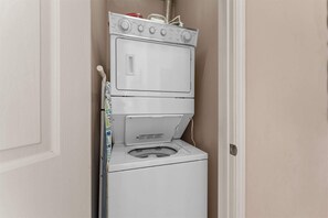 A compact washer and dryer unit in a small laundry room. - Yakov's Pointe - Pool Access (Hollister)
