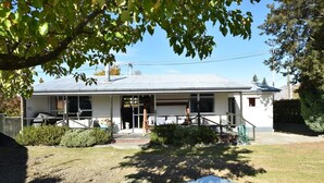A single-story house with a covered porch, a front door, and a small front yard. - Fabulous Family Stay (Twizel)