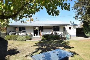 A single-story house with a covered porch, a front door, and a small front yard. - Fabulous Family Stay (Twizel)