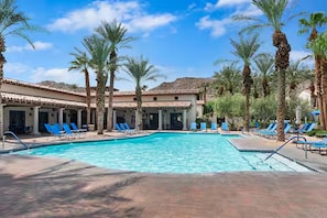 A pool area with multiple lounge chairs and palm trees. - Luxury-Remodeled-Pools-Patios, Ground Floor-3 BD 2BA 12 Pools Jacuzzi Views (La Quinta)