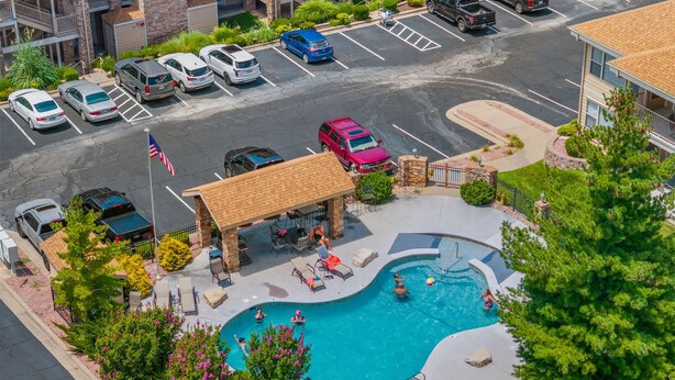 A swimming pool area with lounge chairs, a covered seating area, and a flag. - Smirnoff Pointe - Lakefront (Hollister)