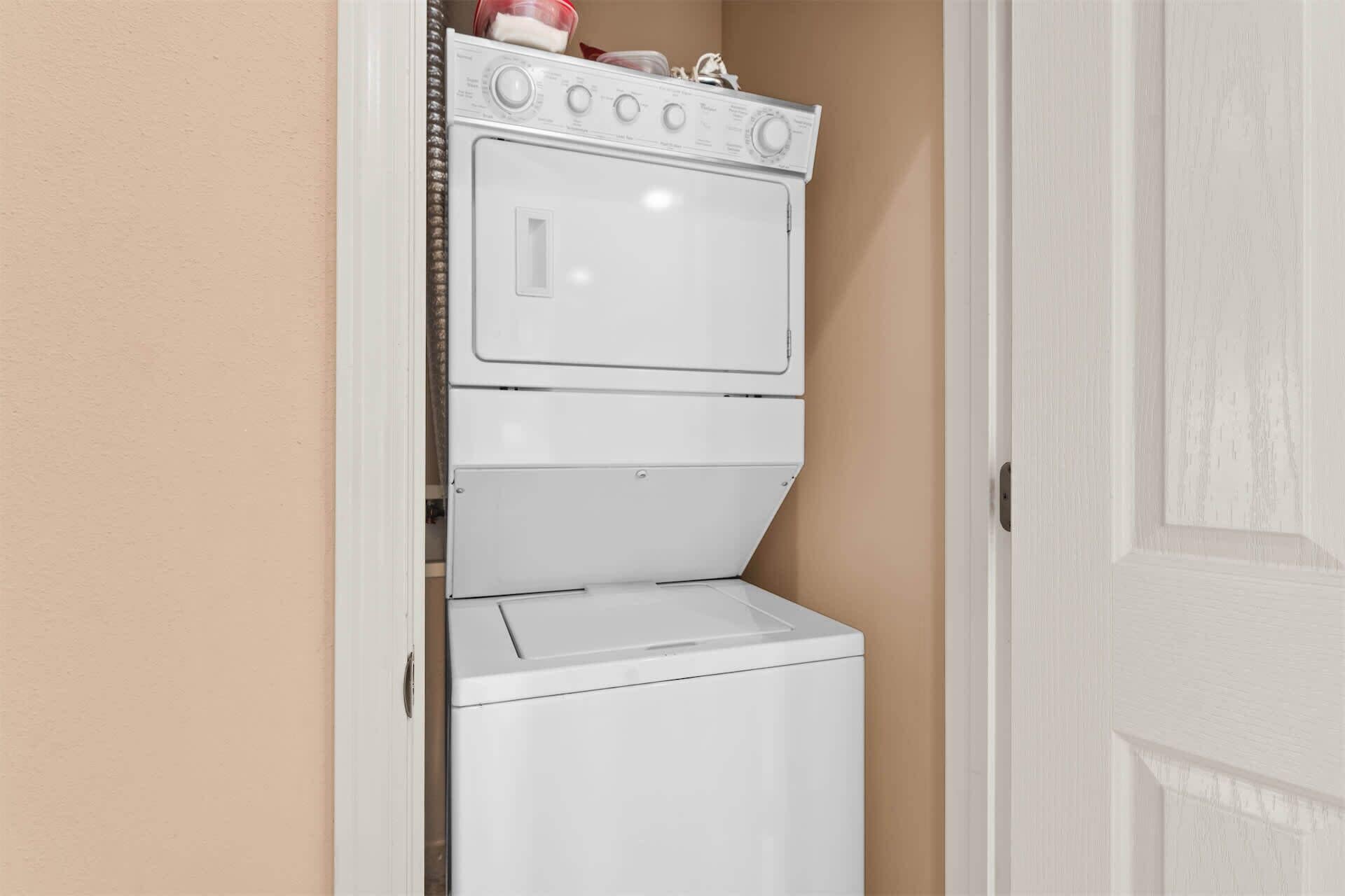 A compact laundry room with a stacked washer and dryer.
