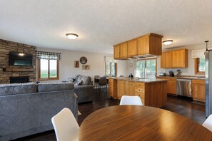 A modern kitchen with wooden cabinets, a built-in oven, and a stainless steel refrigerator.