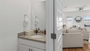 Un baño con encimera de granito, un lavabo y un espejo.