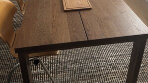 A wooden dining table with a green lamp, two placemats, and a chair. - Vintage Art Lodge 4BR/2BA Full Home in Bay View (Milwaukee)