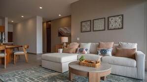 Una sala moderna con un conjunto de sofás, una mesa de centro y un comedor con sillas.