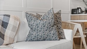 A white sofa with patterned cushions and a throw blanket. - The Willow | Boutique 1BR w/ Balcony (Edmonton)