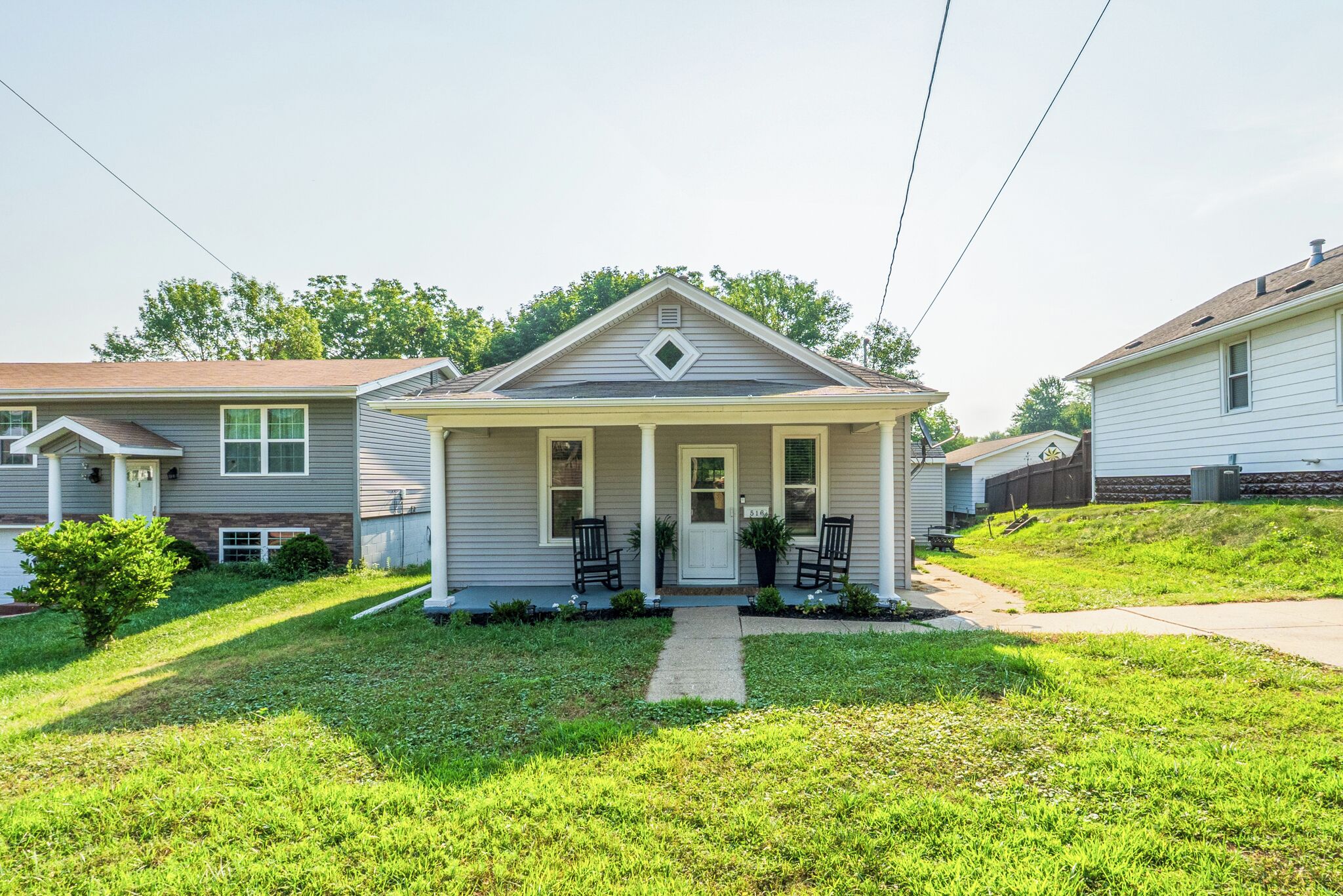 A single-story house with a front porch, a small front yard, and a mailbox.