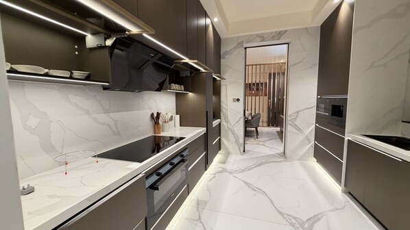 A modern kitchen with a marble backsplash, stainless steel appliances, and a sleek design.