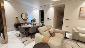 Ein modernes Wohnzimmer mit Essbereich, ausgestattet mit einer Couch, einem Couchtisch und einem Esstisch für sechs Personen.