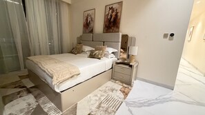 A modern bedroom with a large bed, bedside tables, and artwork on the walls. - Grand Residence 3 bedroom deluxe appartment with club house (Kinshasa)