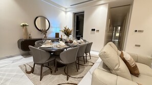 A dining area with a round table set for six, surrounded by six chairs.