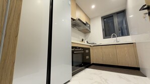 Uma cozinha moderna com forno embutido, máquina de lavar louça e janela sobre a pia.