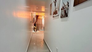 A hallway with a tiled floor leading to a room with a curtain. - 1 bedroom Apartment in Kintambo Velodrome secure clean  with gym (Kinshasa)