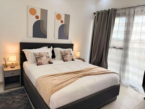 A neatly made bed with a headboard, two bedside tables with lamps, and abstract wall art. - 2 Bedroom large apartment with terrace in a secured building (velodrome)
