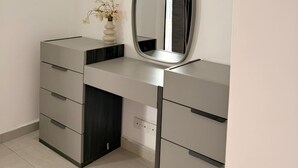 En modern sminkbord med en spegel, en vas med blommor och en inbyggd lådmodul.