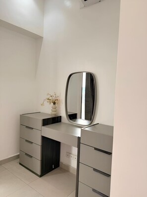 A modern vanity with a mirror, a vase with flowers, and a built-in drawer unit. - 2 Bedroom large apartment with terrace in a secured building (velodrome)