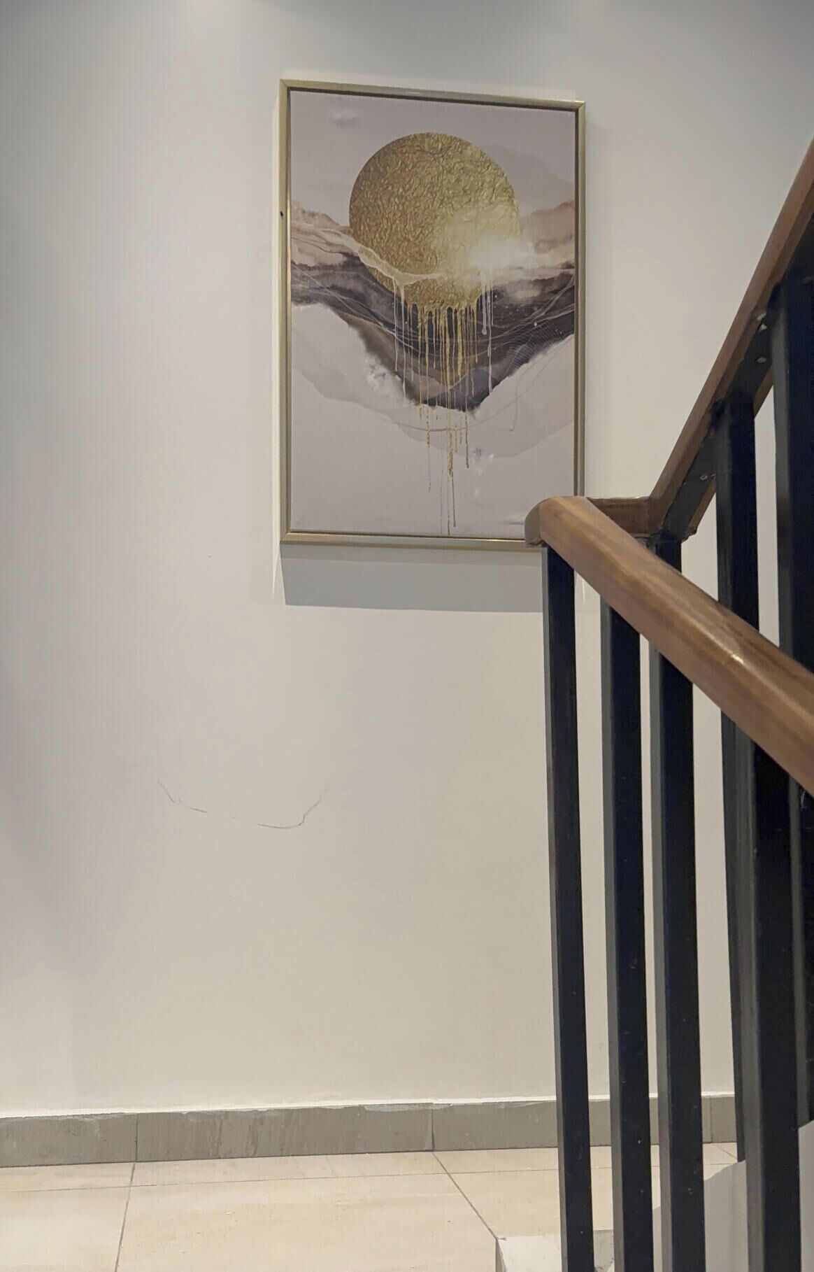 Un escalier muni d’une rampe et d’une œuvre d’art encadrée accrochée au mur.