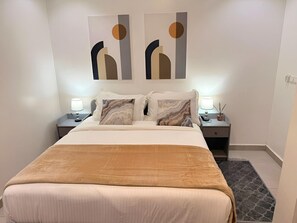 A hotel room with a large bed, two bedside tables with lamps, and abstract wall art. - 2 Bedroom large apartment with terrace in a secured building (velodrome)