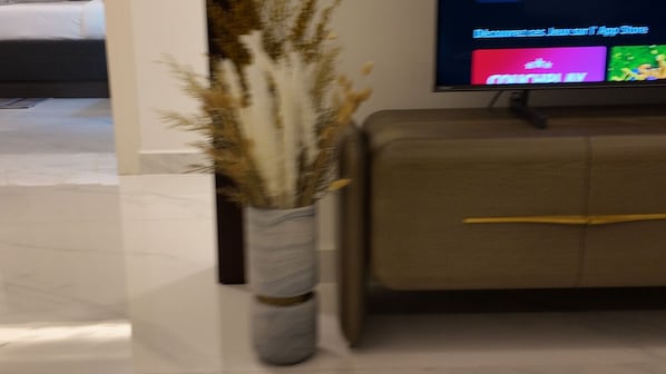 A living room with a sofa and a television displaying an app store.