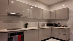 A modern kitchen with a built-in oven, microwave, and coffee maker.