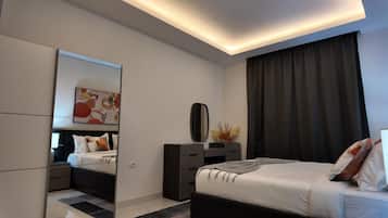 A modern bedroom with a bed, bedside tables, a dresser, a mirror, and a painting on the wall.