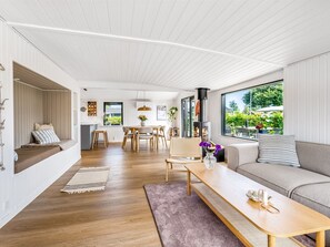 A modern interior with a dining area, sofa, and a fireplace. - "Varnava" - 300m from the sea by Interhome (Grenaa)