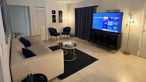 A modern living room with a sofa, two armchairs, a coffee table, a flat-screen TV, and a TV stand. - Cozy 2-bedroom villa with Pool in sunny Miami (Miami)