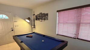 A pool table with a single white cue ball, a lamp, and a door with a window. - Cozy 2-bedroom villa with Pool in sunny Miami (Miami)