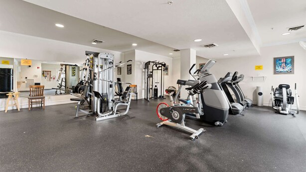 Ett gym med olika typer av träningsutrustning, inklusive löpband och styrketräningsmaskiner.